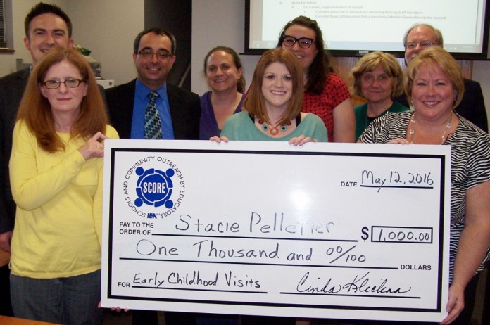 Stacie Pelletier at the center of the BIG SCORE check, along with her Board of Education and school district administrators. Stacie Pelletier at the center of the BIG SCORE check, along with her Board of Education and school district administrators.